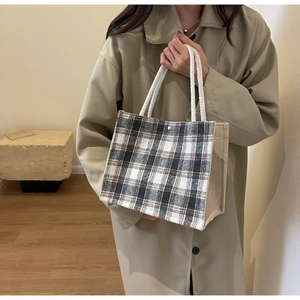 Détail du sac cabas en tweed à carreaux avec poignées en corde et bouton pression doré