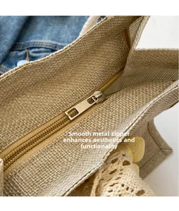 Close-up of golden metal zipper closure and lace trim on natural jute woven tote bag