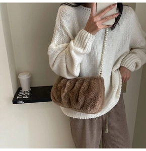 Detail of plush brown crossbody bag with large pearl strap and soft faux fur texture