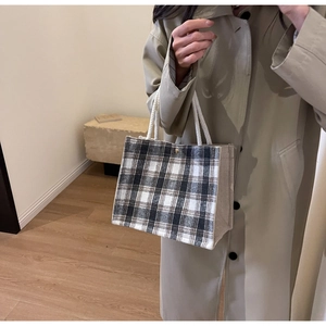 Gros plan détaillé d'un sac cabas à carreaux élégant avec poignées en corde et fermoir