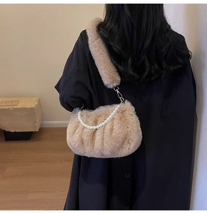Detail of plush faux fur shoulder bag with pearl chain handle and golden metal hooks
