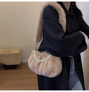 Detail of plush faux fur shoulder bag with elegant pearl chain and soft wide strap