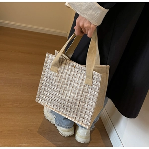 Close-up of the beige and brown tweed patchwork tote bag with gold metal buckle detail