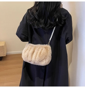Detailed view of plush faux fur crossbody bag with elegant pearl chain strap decoration