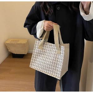 Close-up of multicolor woven tweed tote bag featuring light beige canvas and gold buckle
