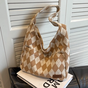 Brown and beige diamond lattice canvas tote bag with fashion leather patch on a sofa