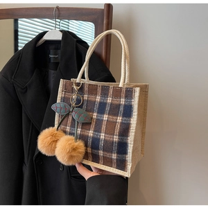 Detail of vintage plaid mini tote bag featuring a plush double cherry charm and cord handle