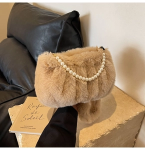 Detail of plush faux fur shoulder bag with elegant pearl strap and soft ruched texture