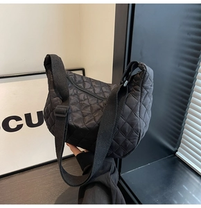 Detailed close-up of quilted black nylon crossbody bag with premium rhombic texture
