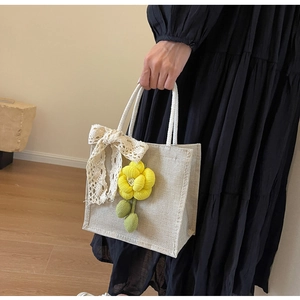 Detail of linen handbag with 3D yellow fabric flower and white lace bow decoration