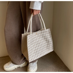 Detailed view of woven tote bag with checkered pattern and soft rope handles for daily use