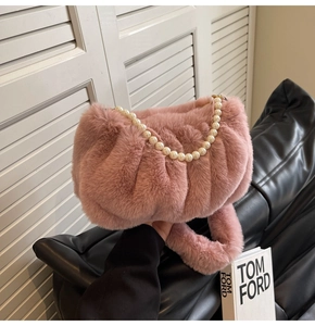 Detailed view of a pink faux fur cloud bag featuring elegant pearl strap and soft texture