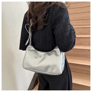 Close-up of silver matte pleated shoulder bag with soft leather texture on a model