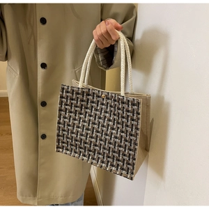 Close-up of woven tote bag with thick cotton rope handles and gold metallic button