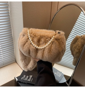 Detail of soft khaki faux fur bag with elegant large pearl handle and metal hooks