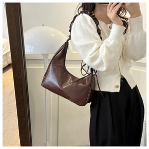 Detail of dark brown hobo bag featuring a unique pleated ruffled shoulder strap design