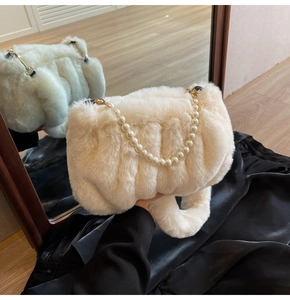 Close-up of plush faux fur clouds bag featuring elegant pearl chain and soft texture
