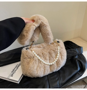 Detail of plush beige faux fur handbag with elegant white pearl decorative chain