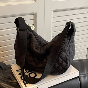 Quilted black half-moon crossbody bag with diamond patterns and adjustable strap