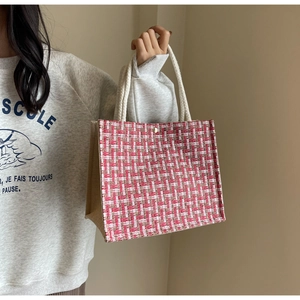 Detail of red and white tweed woven tote bag with white rope handles for daily commute