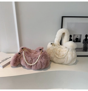 Detailed view of plush handbags with pearl handles and decorative pom-poms in soft colors