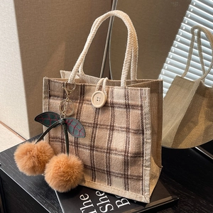 Retro plaid tote bag with large wooden button and fuzzy cherry charms in soft sunlight