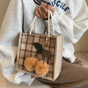 Brown checkered lunch tote bag with rope handles and oversized plush cherry charms
