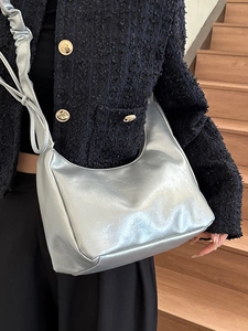 Silver metallic hobo shoulder bag with pleated strap and modern crescent shape design