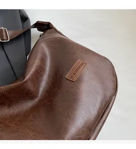 Gros plan sur la texture du cuir vintage marron et l'étiquette FASHION du sac