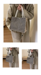 Detail of tweed woven tote bag with white rope handles and golden metal snap closure