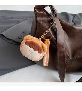 Detail of cute plush doll pendant with Sweet strap on brown leather shoulder bag