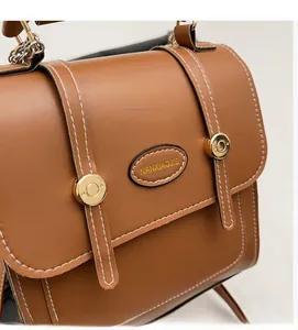 Close-up of brown vintage leather backpack with white stitching and gold hardware detail