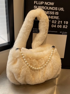 Plush cream crossbody bag with pearl chain handle and faux fur texture for winter