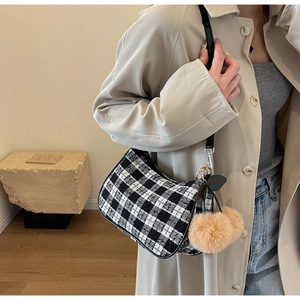 Chic black and white checkered tweed underarm bag with decorative brown faux fur pompom charm