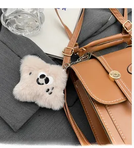 Detail of cute plush panda charm attached to a vintage brown leather backpack bag