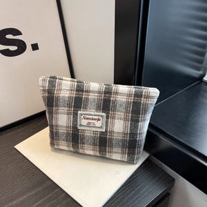 Detail shot of plaid fabric cosmetic bag with Nanaxiaojie label and minimalist design