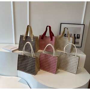 Detail of woven tote bags showing texture and handles in brown, red, and beige plaid patterns