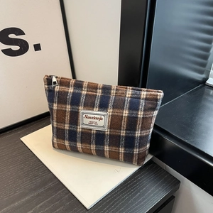 Close-up of vintage plaid makeup bag featuring premium fabric and secure silver zipper
