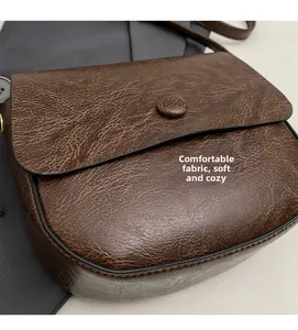 Macro shot of brown retro saddle bag with high-quality oil wax textured leather finish