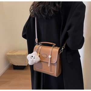 Close-up of a brown vintage PU leather backpack with contrast stitching and star charm
