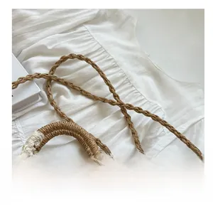 Detail of woven straw bag showing fine craftsmanship with elegant white lace bow decoration