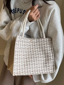 Minimalist beige woven tote bag with brown textures and gold buckle for women