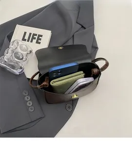 Interior view of brown leather saddle bag showing capacity for phone and wallet