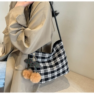 Détail du sac cabas en tweed à damier avec charm cerise et bandoulière en cuir noir