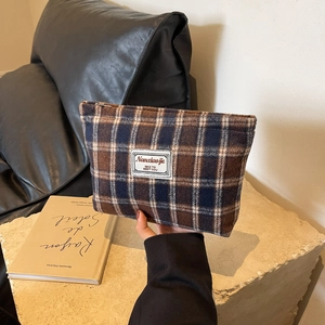 Detail of wool blend plaid cosmetic bag with zipper and vintage British style label