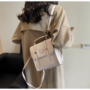 Close-up of retro beige backpack with leather texture and metal buckle detail on a model