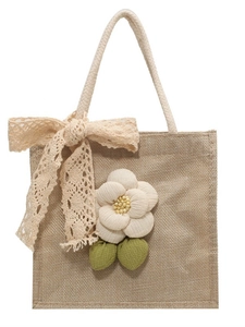 Linen tote bag with lace bow and fabric flower embellishment on white background