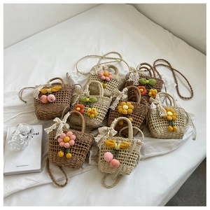 Detail of handmade straw bag featuring crochet floral patterns and lace bow accents