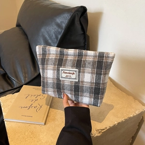 Close-up of retro brown plaid toiletry bag with woven label and textured fabric