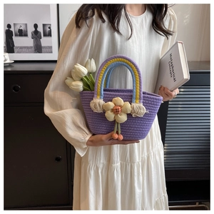 Detail of purple woven handbag with yellow floral accents and rainbow handle